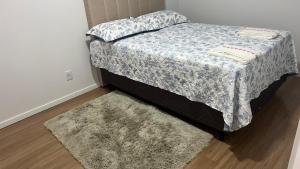 a bedroom with a bed with a rug and a bed sidx sidx sidx at Gaudi in Santa Cruz do Sul