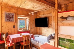 a dining room with a table and a bed in a cabin at Neuhaus Alm in Gerlosberg