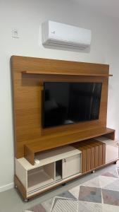 a entertainment center with a flat screen tv on a wall at Gaudi in Santa Cruz do Sul