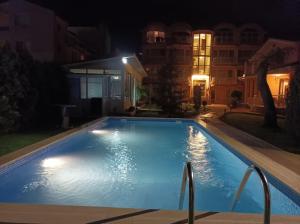 a swimming pool at night with lights on it at Sunny House in Kranevo