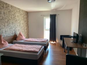 a hotel room with two beds and a desk at Stundenhotel Krieger in Büren