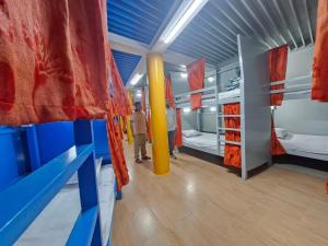 a room with three bunk beds and a man standing in it at International Dormitory Mohsin Plaza in Sreemangal