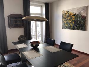 a black dining room table with chairs and a painting at My Wonderland in Salzburg