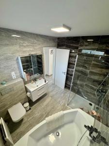 a bathroom with a tub and a toilet and a sink at BB Riviera Resort in Balatonboglár +5 photos