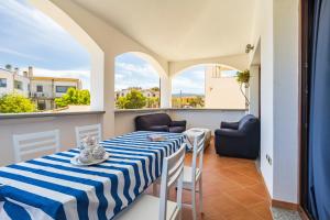 a room with a table and chairs and a balcony at Sa Omu Bianca in Tortolì