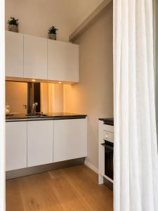 a kitchen with white cabinets and a curtain at Angoli di pace - Appartamento trilocale in Muralto
