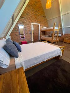 a large bed in a room with a brick wall at Cabaña Premium Yvyja de La Mala Junta in Atyrá +45 photos