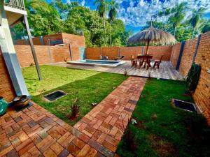 a backyard with a patio with a table and an umbrella at Cabaña Premium Yvyja de La Mala Junta in Atyrá