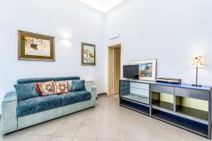 a living room with a couch and a tv at Al Portico in Avola