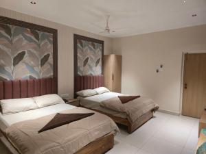 a bedroom with two beds and a painting on the wall at Hotel Royal Akkamahadevi in Sundi Penta