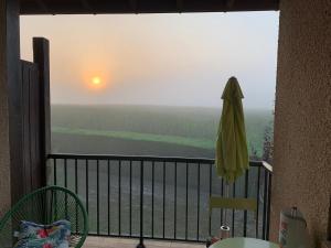 a balcony with an umbrella and a view of the ocean at Barbotinecures vacations in Barbotan-les-Thermes