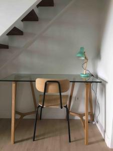a glass desk with a chair and a plant on it at Barbotinecures vacations in Barbotan-les-Thermes