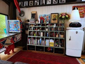 a room with a book shelf with books and a refrigerator at Villa Georges in Issy-les-Moulineaux