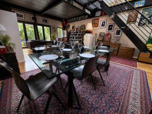 a dining room with a table and chairs on a rug at Villa Georges in Issy-les-Moulineaux