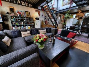 a living room with a couch and a table with flowers on it at Villa Georges in Issy-les-Moulineaux