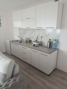 eine Küche mit weißen Schränken und einer Arbeitsplatte in der Unterkunft Harmony Haus in Visoko