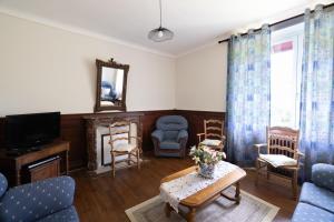 a living room with blue chairs and a tv at Gîte Zelai Begi in Aldudes