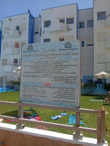 a large sign in front of a building at Appartement de vacance à Tanmia Bloc 13 in Martil +4 photos