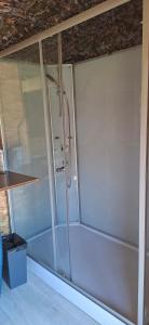 a bath tub with a shower in a room at Logement insolite tente glamping in Parigné-lʼÉvêque