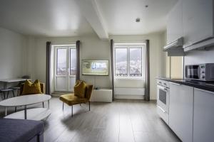 a kitchen with a table and chairs and a kitchen with a microwave at Magic Kloverhuset Harbour Hotel, a member of Radisson Individuals in Bergen