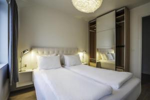 a bedroom with a large white bed and a mirror at Magic Kloverhuset Harbour Hotel, a member of Radisson Individuals in Bergen