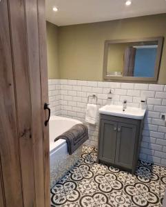 a bathroom with a tub and a sink and a mirror at Idyllic period cottage, Ramsbury, Nr Marlborough in Ramsbury +18 photos