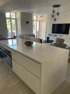 a kitchen with a white island in a living room at Le Reflet du Lac in Annecy