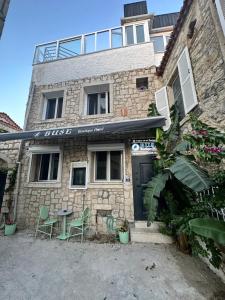 a building with a table and chairs in front of it at Hotel Buse in Alaçatı