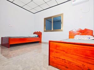 two beds in a white room with a window at Keitaya Dubreka Guinea in Conakry
