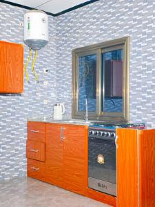 a kitchen with a stove and a window at Keitaya Dubreka Guinea in Conakry