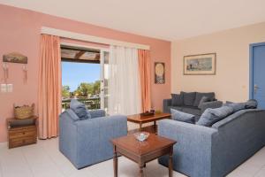 a living room with two couches and a table at Sunrise Stone Villa in Agios Nikolaos +18 photos