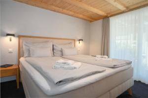 a bedroom with a large white bed with towels on it at Chalet Eiger View - GRIWA RENT in Grindelwald