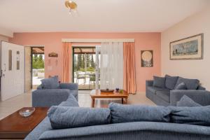 a living room with two blue couches and a table at Sunrise Stone Villa in Agios Nikolaos