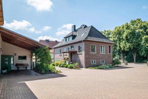 a large brick house with a gambrel roof at Pension Pusteblume in Meyenburg