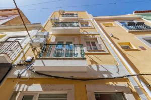 a tall yellow building with a balcony at Bocage Blue Heaven I, By Home Match in Setúbal