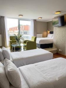a hotel room with two beds and a living room at Hotel Taormina Brussels Airport in Zaventem +100 photos