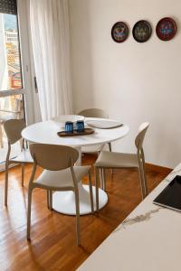 a dining room with a white table and chairs at Verde Acqua two Apartments in Lecco
