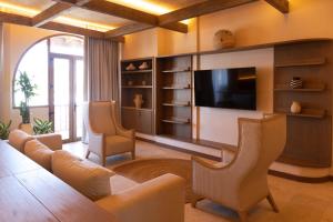 a living room with a tv and a couch and chairs at Hotel El Balconario by Faranda Boutique in Cartagena de Indias