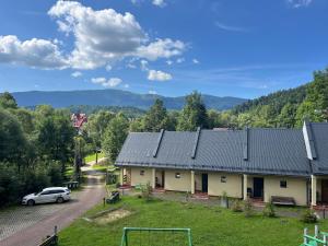 a house with a car parked in front of it at Osada Babiogórska - domki gościnne in Zawoja