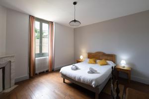 a white bedroom with a bed and a fireplace at Gîte Zelai Begi in Aldudes
