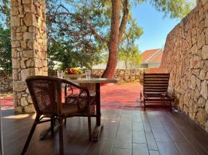 a table and chairs on a patio with a stone wall at Green Garden Gajac in Gajac