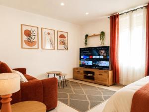 a living room with a television and a couch at Studio Cosy tout équipé 40m2 - Entrée autonome - Parking gratuit in Distroff