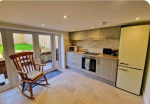 a kitchen with a chair and a refrigerator at Idyllic period cottage, Ramsbury, Nr Marlborough in Ramsbury