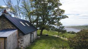 a stone house with a blue roof with a view of a river at The Croft Collective in Oban