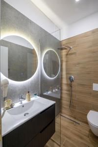 a bathroom with a sink and a toilet and a mirror at SulMare Rooms in Sarandë