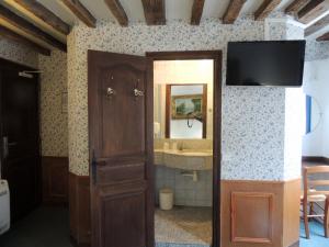 a bathroom with a television and a door with a mirror at Hotel du Lys in Paris