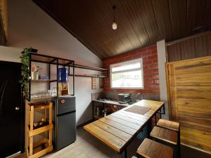 a small kitchen with a wooden table and a refrigerator at Anagrama house in Baños