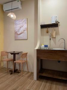 a kitchen with a sink and a table and chairs at The Miá home in Can Tho