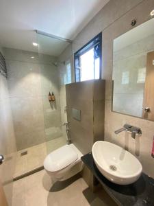 a bathroom with a toilet and a sink and a mirror at Hotel Banyan Crest in Solapur +30 photos