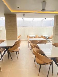 a classroom with tables and chairs in a cafeteria at Hotel Banyan Crest in Solapur